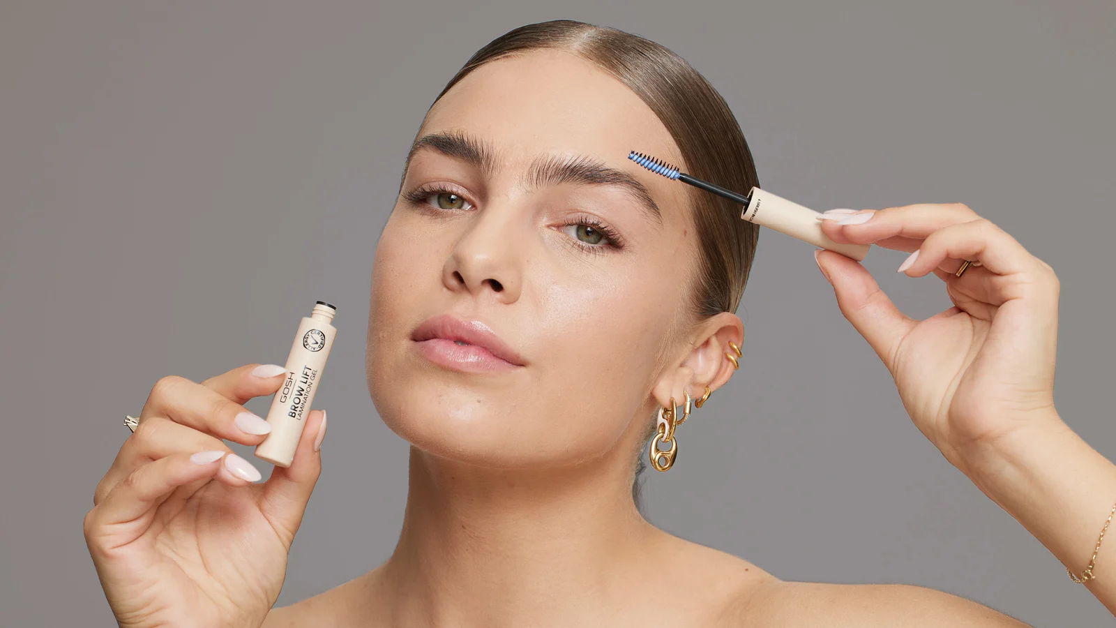 Her ses et kampagnebillede for GOSH Copenhagen med en person, der påfører Brow Lift på øjenbrynet. Personen holder både produktet og børsten ved ansigtet.