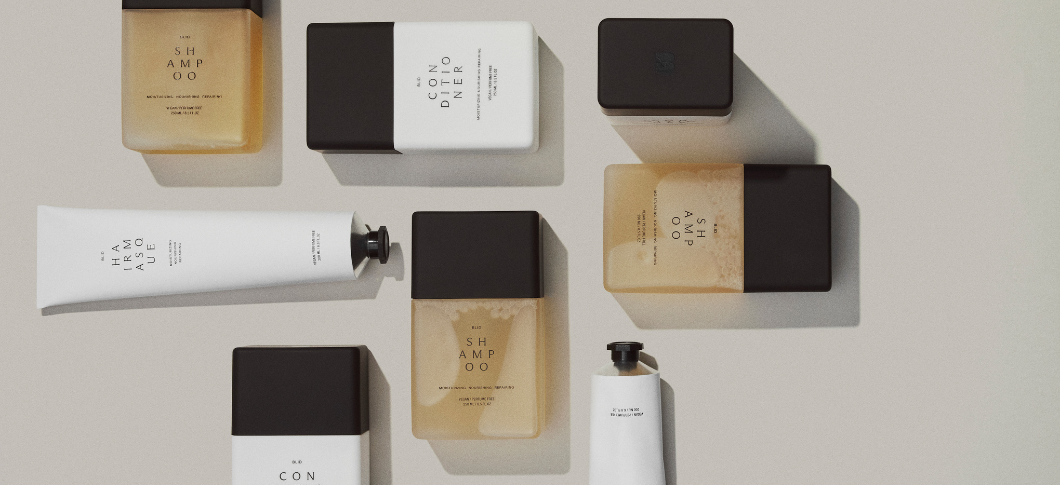 Minimalistisk sortiment af hårplejeprodukter: flasker med 'SHAMPOO', flasker med 'CONDITIONER' og en tube 'HAIR MASQUE'.