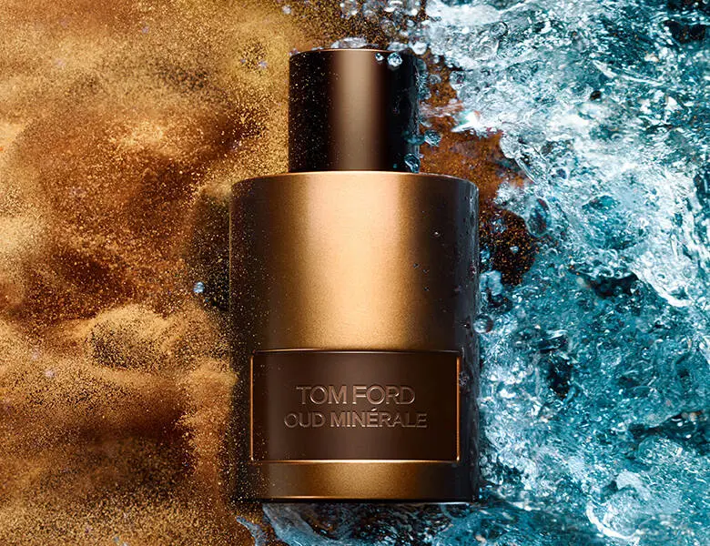 Her ses en guld og blå baggrund med en bronzefarvet Tom Ford parfume.