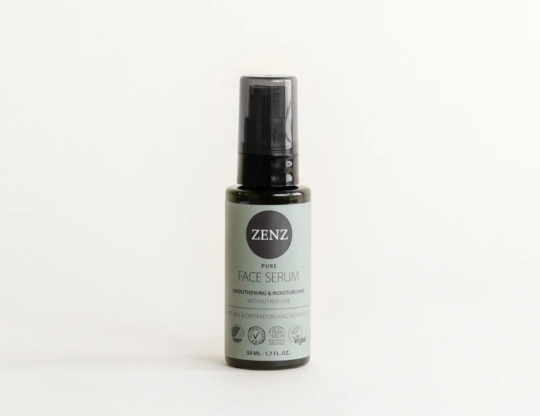 Her ses et ZENZ face serum i en mørk flaske med pumpe på en lys baggrund.