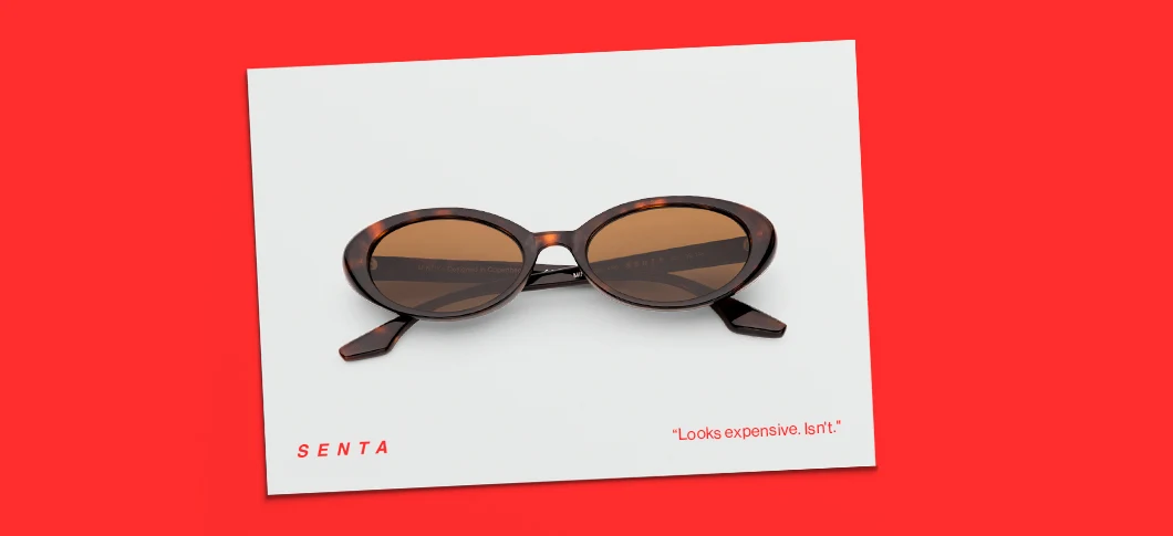 Brune skildpaddemønstrede ovale solbriller på et hvidt kort. Tekst lyder 'SENTA' og 'Looks expensive. Isn't.'.