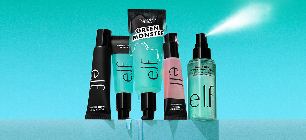Her ses et billede med flere makeup-produkter fra e.l.f. placeret side om side mod en turkis baggrund. På produkterne står teksten “e.l.f.” samt blandt andet “GREEN MONSTER” og “POWER GRIP”. Produkterne er i sorte, grønne og lyserøde emballager.