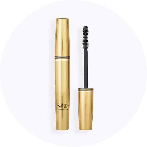Her ses en guld mascara på en lys baggrund.
