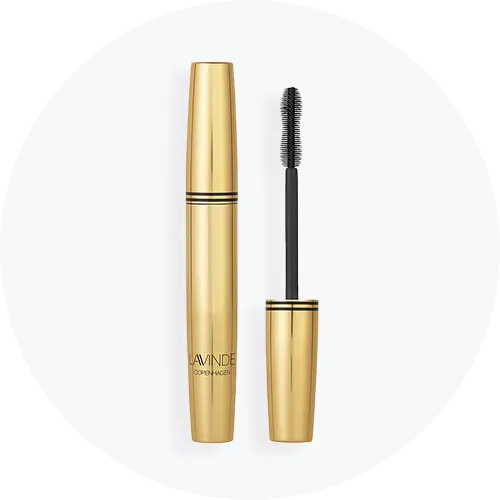 Her ses en guld mascara på en lys baggrund. 