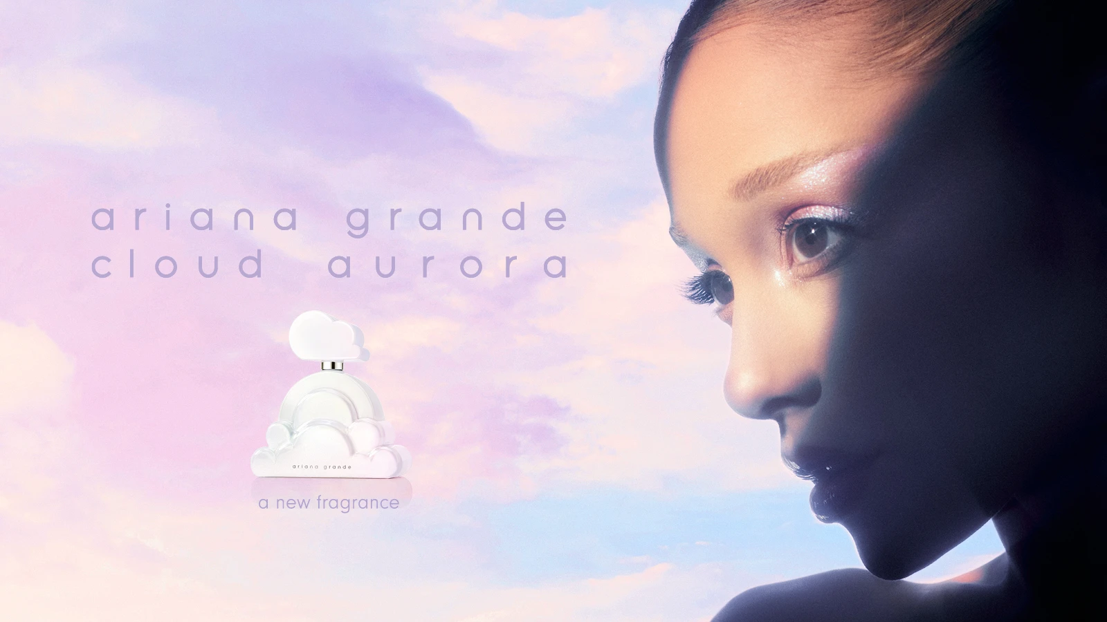 Her ses et kampagnebillede for Ariana Grande Cloud Aurora med et nærbillede af en person med skinnende øjenmakeup til højre og parfumeflakonen formet med skyer til venstre. På billedet står “Ariana Grande Cloud Aurora” og “A new fragrance” mod en rosa, lilla og lyseblå himmel.