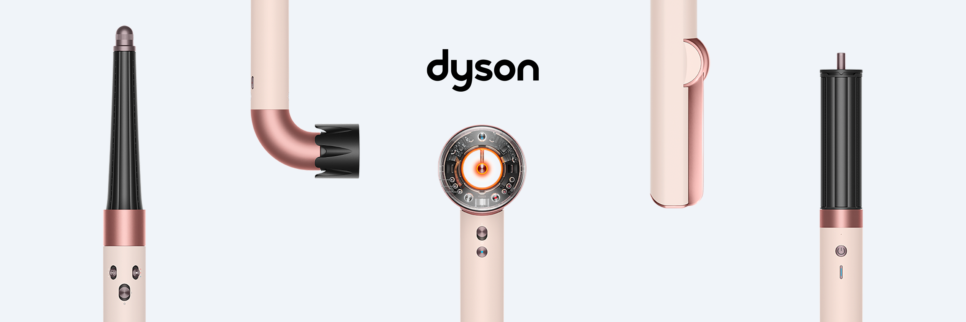 Her ses et kampagnebillede for Dyson Beauty med forskellige hårstylingprodukter og tilbehørsdele i Ceramic Pink/Rose Gold. Produkterne er vist fra forskellige vinkler mod en lys, kølig baggrund, mens det sorte Dyson-logo står centralt. Det minimalistiske layout og de rosa metalliske detaljer fremhæver seriens design og forskellige stylingfunktioner.