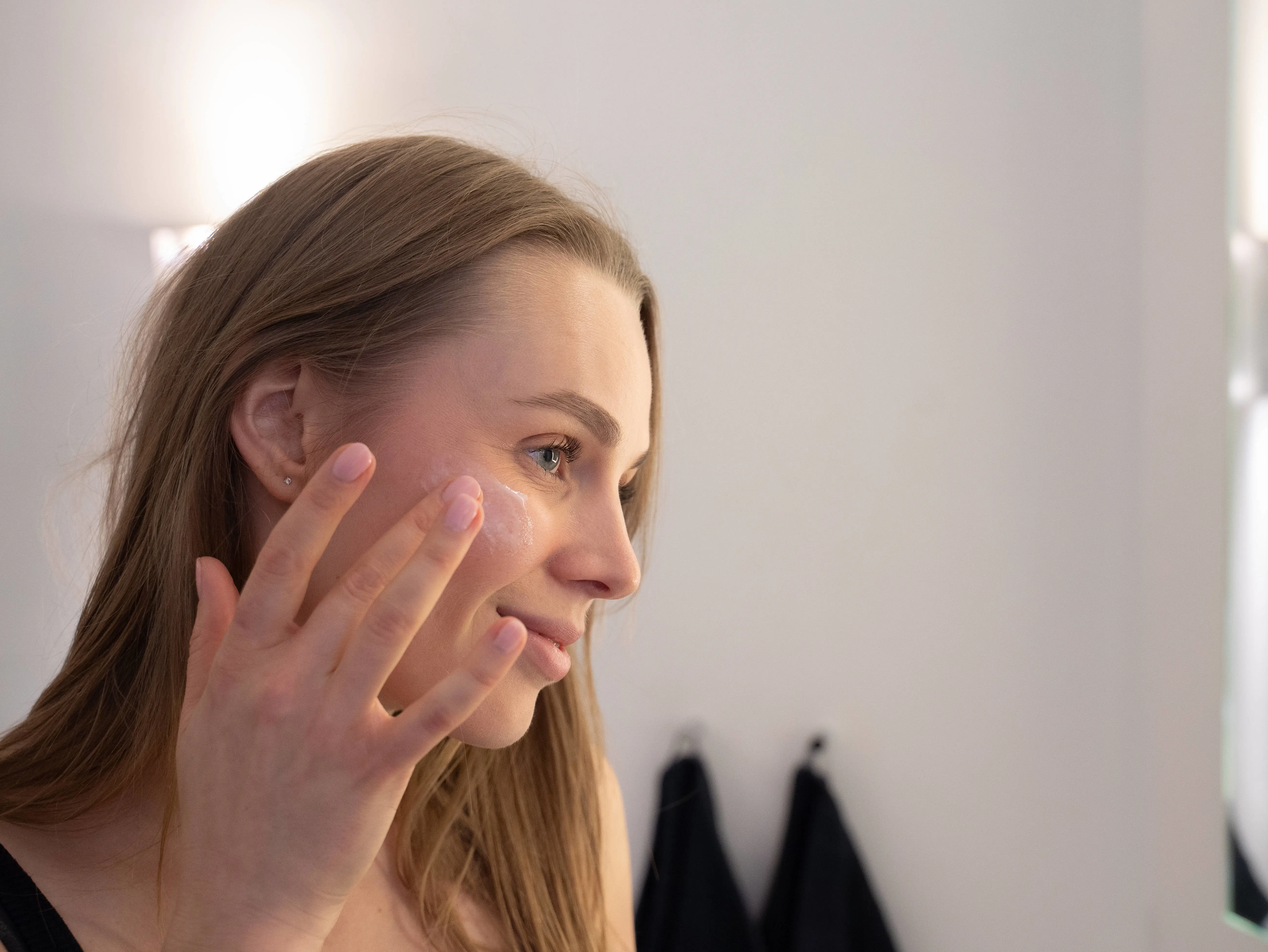 Her ses en person der påfører solcreme på ansigtet