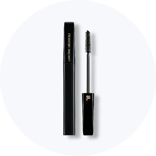 Her ses Lancôme Définicils Mascara i en sort emballage med guldfarvet tekst. Mascaraen er åben, så den sorte mascarabørste ses ved siden af beholderen.