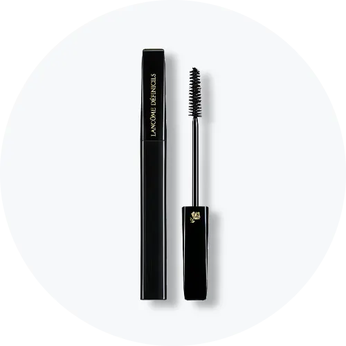 Her ses Lancôme Définicils Mascara i en sort emballage med guldfarvet tekst. Mascaraen er åben, så den sorte mascarabørste ses ved siden af beholderen.