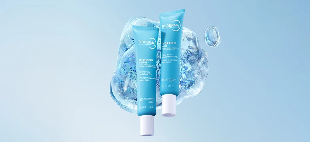 Her ses to BIODERMA Hydrabio ansigtscremer foran en blå baggrund med vanddråber.