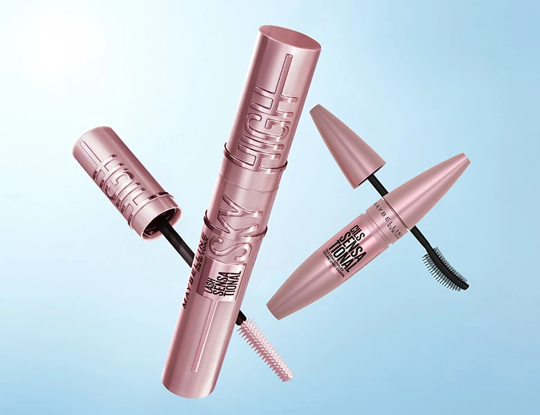 Her ses et billede med flere mascaraprodukter placeret mod en blå baggrund. På produkterne står blandt andet “SKY HIGH” og “SENSATIONAL”. Nogle af mascarerne er åbne, så børsterne er synlige.