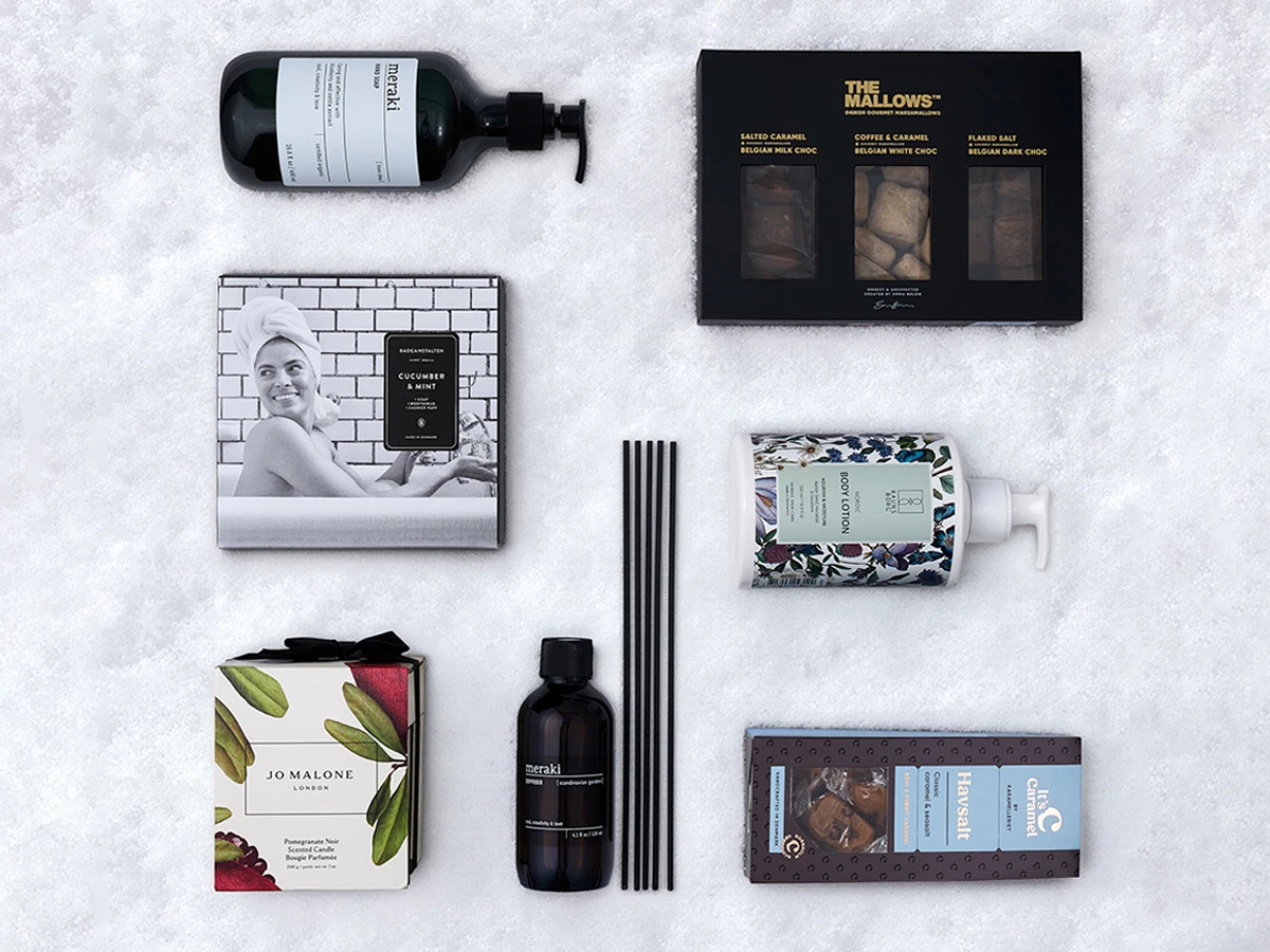 Assortiment af wellness- og gourmetprodukter: Meraki sæbe, Jo Malone lys, The Mallows skumfiduser, It's Caramel.