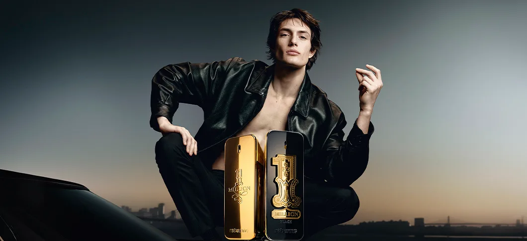 Her ses et billede af en person iført en sort læderjakke siddende ved siden af to parfumeflakoner mod en mørk baggrund. Produkterne er fra Rabanne, og på flakonerne står blandt andet “1 MILLION” og “1 MILLION ELIXIR”.