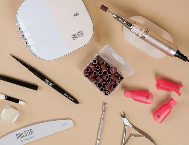 Her ses forskellige af Nailsters negle-værktøjer på en beige baggrund.