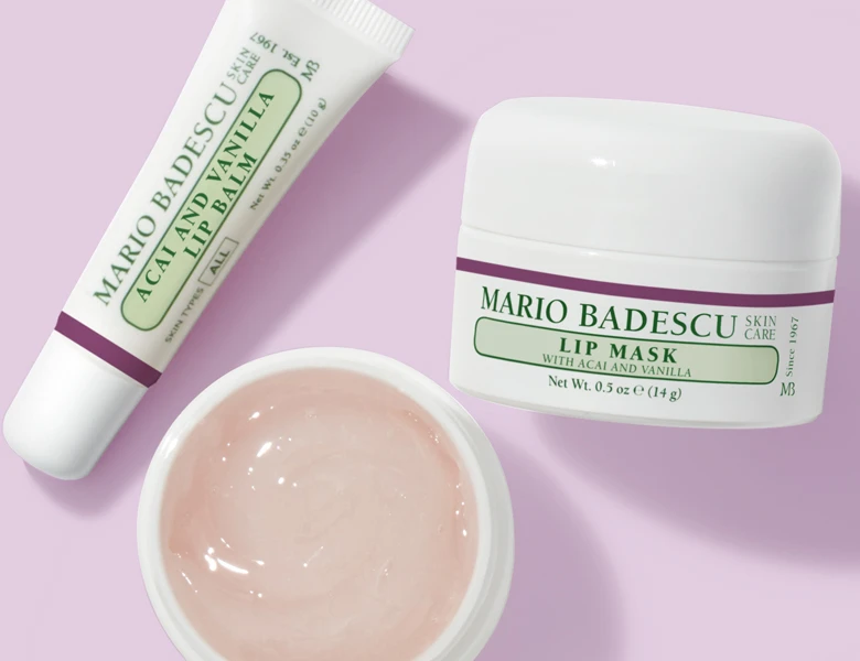 Her ses tre Mario Badescu læbeprodukter på en halv grøn og halv lyserød baggrund.