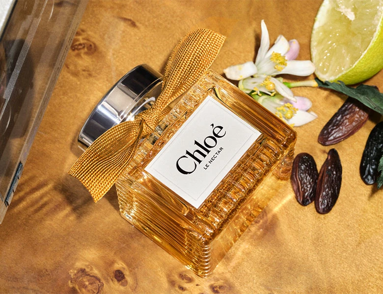 Her ses et billede af Chloé Le Nectar parfume. Flakonen er orange med et orange bånd.