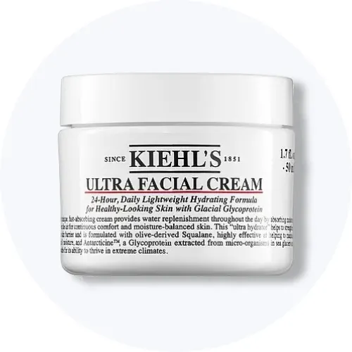 Her ses Kiehl’s Ultra Facial Cream i en hvid krukke på en lysegrå cirkel.