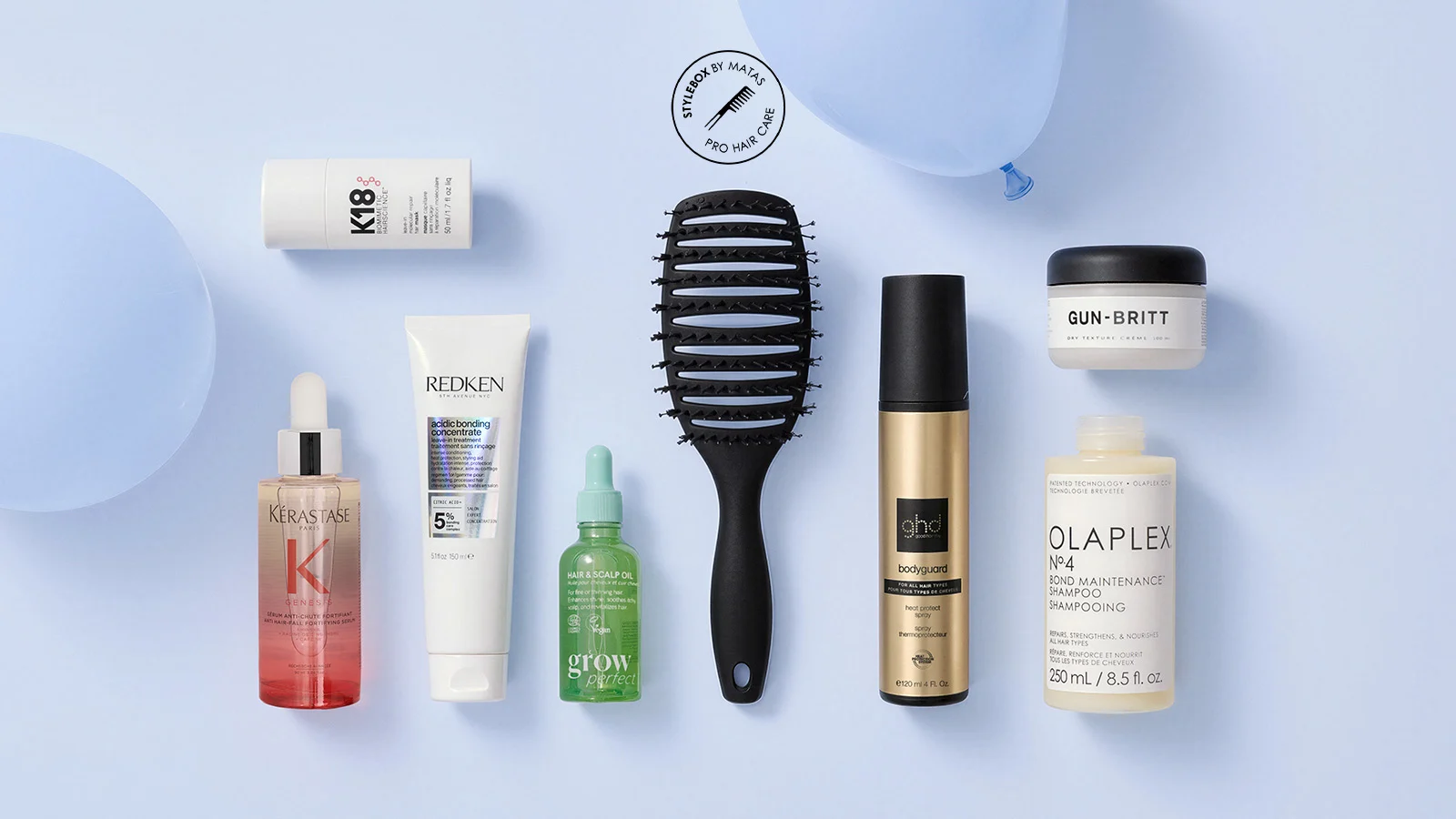Her ses et udvalg af hårpleje- og stylingprodukter fra K18, Kérastase, Redken, Grow Perfect, ghd, Gun-Britt og Olaplex samt en sort hårbørste. Produkterne er arrangeret mod en lyseblå baggrund med teksten “Stylebox by Matas – Pro Hair Care”.