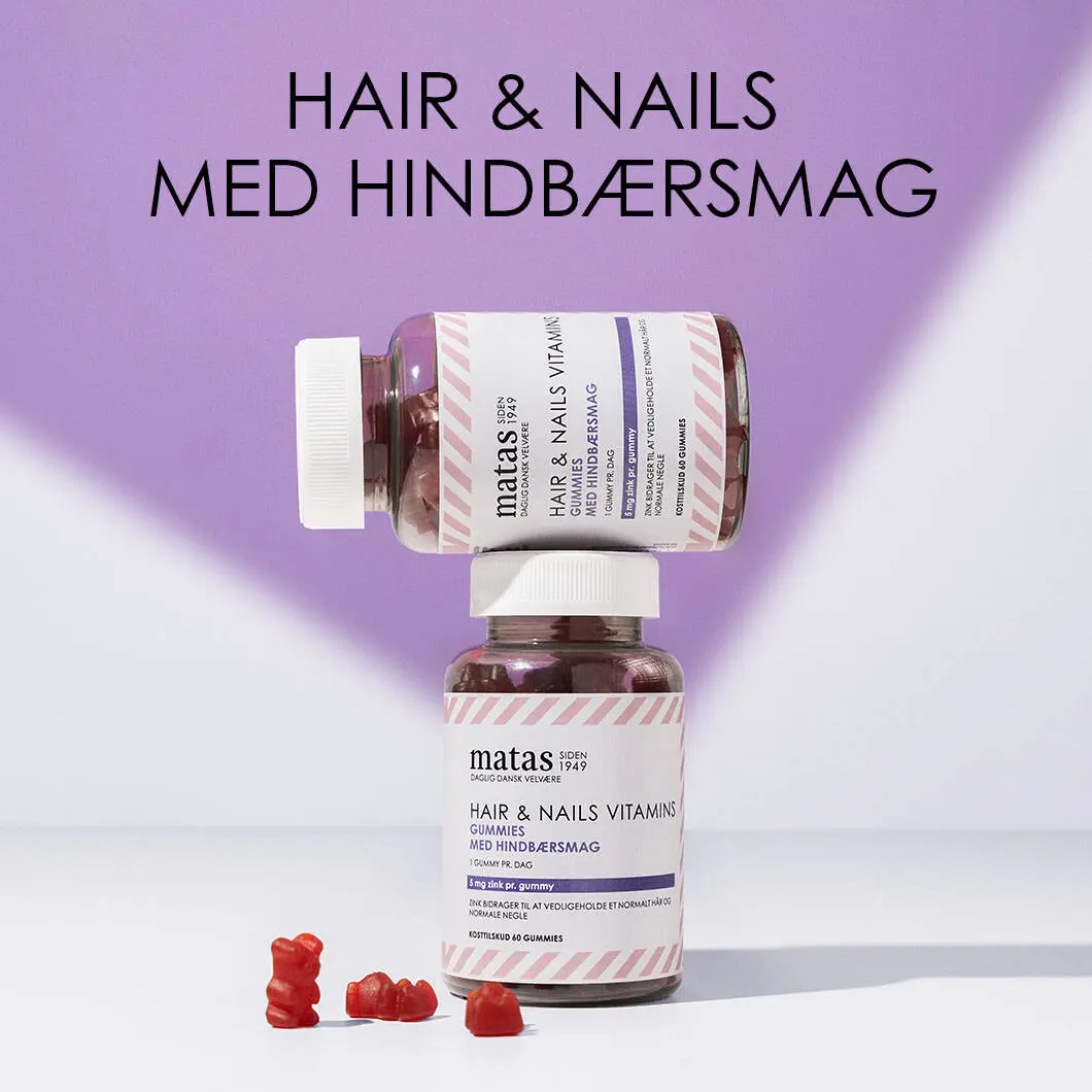 Her ses en lilla og hvid baggrund. Øverst er en sort tekst og nederst er to bøtter af Matas vitaminvingummier med hindbærsmag. Forrest er tre løse vingummier.