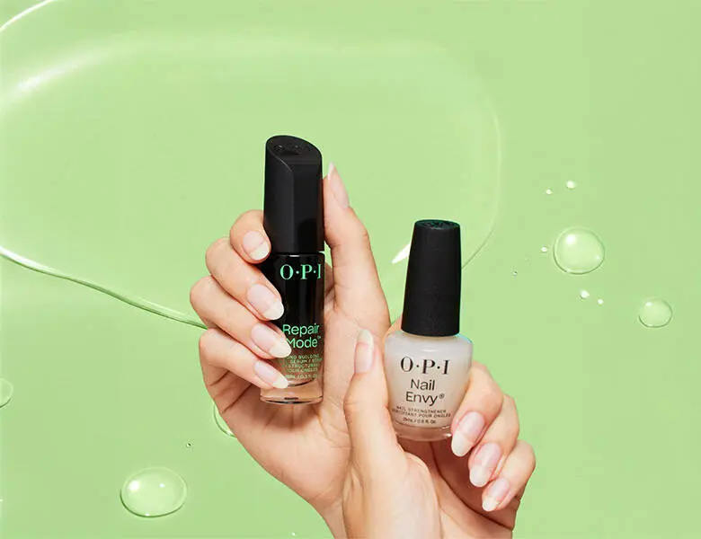 Her ses to OPI produkter holdt oppe foran en grøn baggrund.