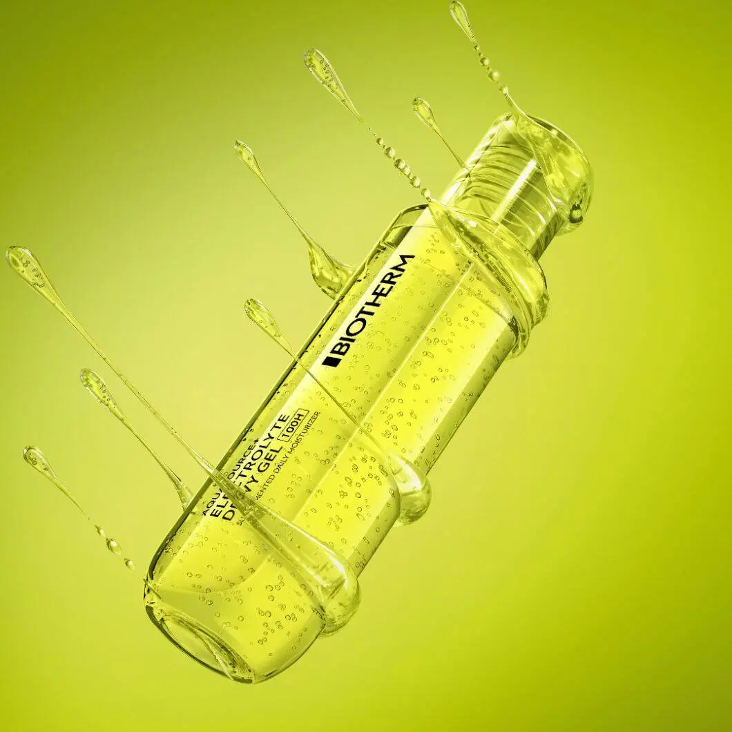 Et nærbillede af en grøn Biotherm Aquasource+ Electrolyte Dewy Gel-flaske mod en limegrøn baggrund. Flasken er omgivet af geléagtige væskesprøjt og dråber, som giver et friskt og energifyldt udtryk. Produktet fremhæves som fugtgivende hudpleje med fokus på hydrering og friskhed.