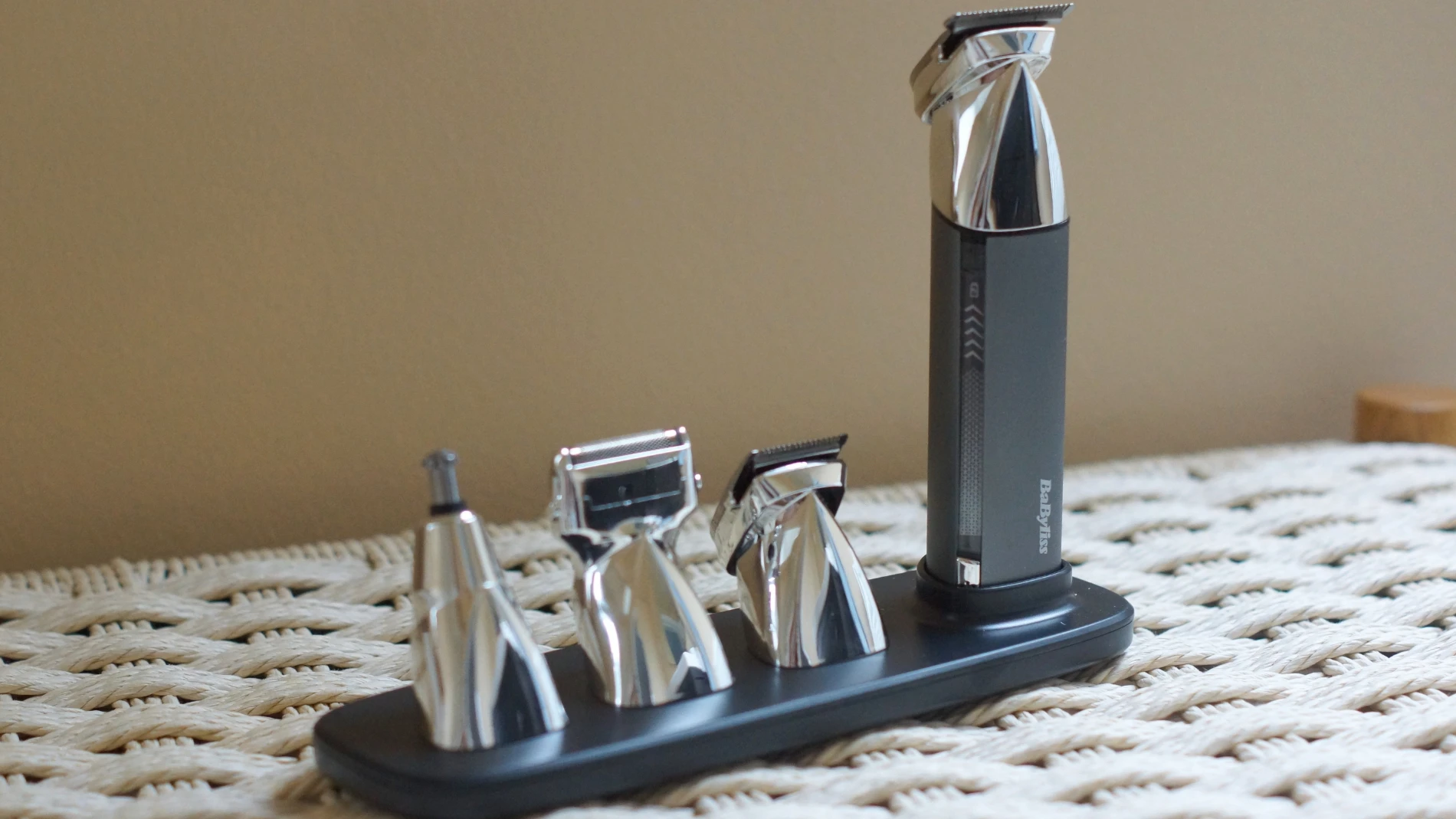 BaByliss plejesæt med sort hovedtrimmer og tre sølvfarvede udskiftelige hoveder på en holder.