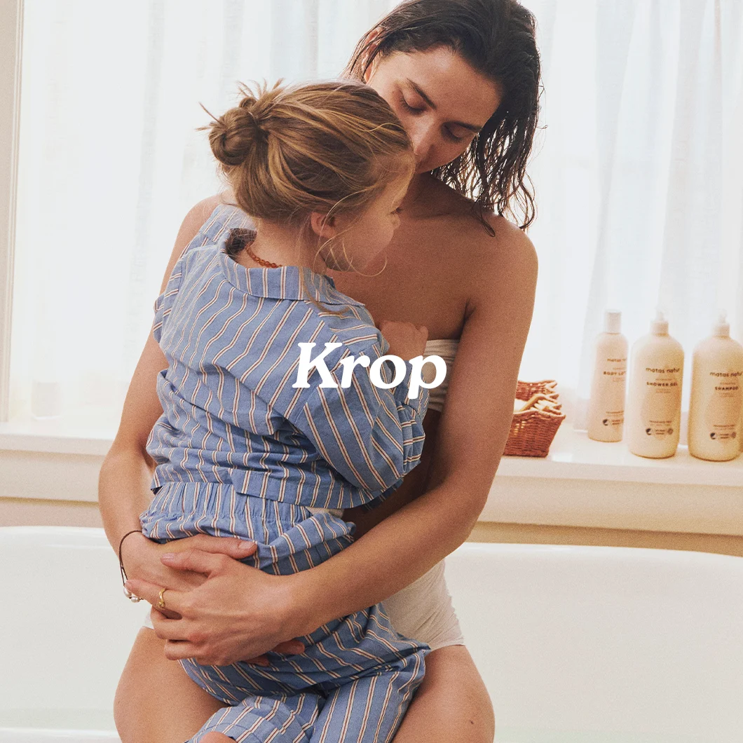Her ses en kvinde, der holder et barn på badeværelset med teksten “Krop” og Matas Natur produkter i baggrunden.