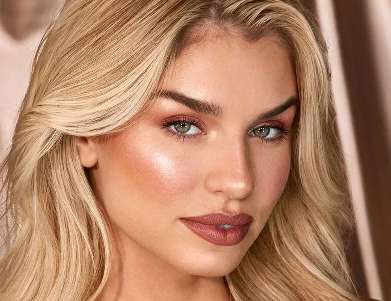Her ses et close-up billede af en kvindes ansigt. Kvinden har en del makeup på.