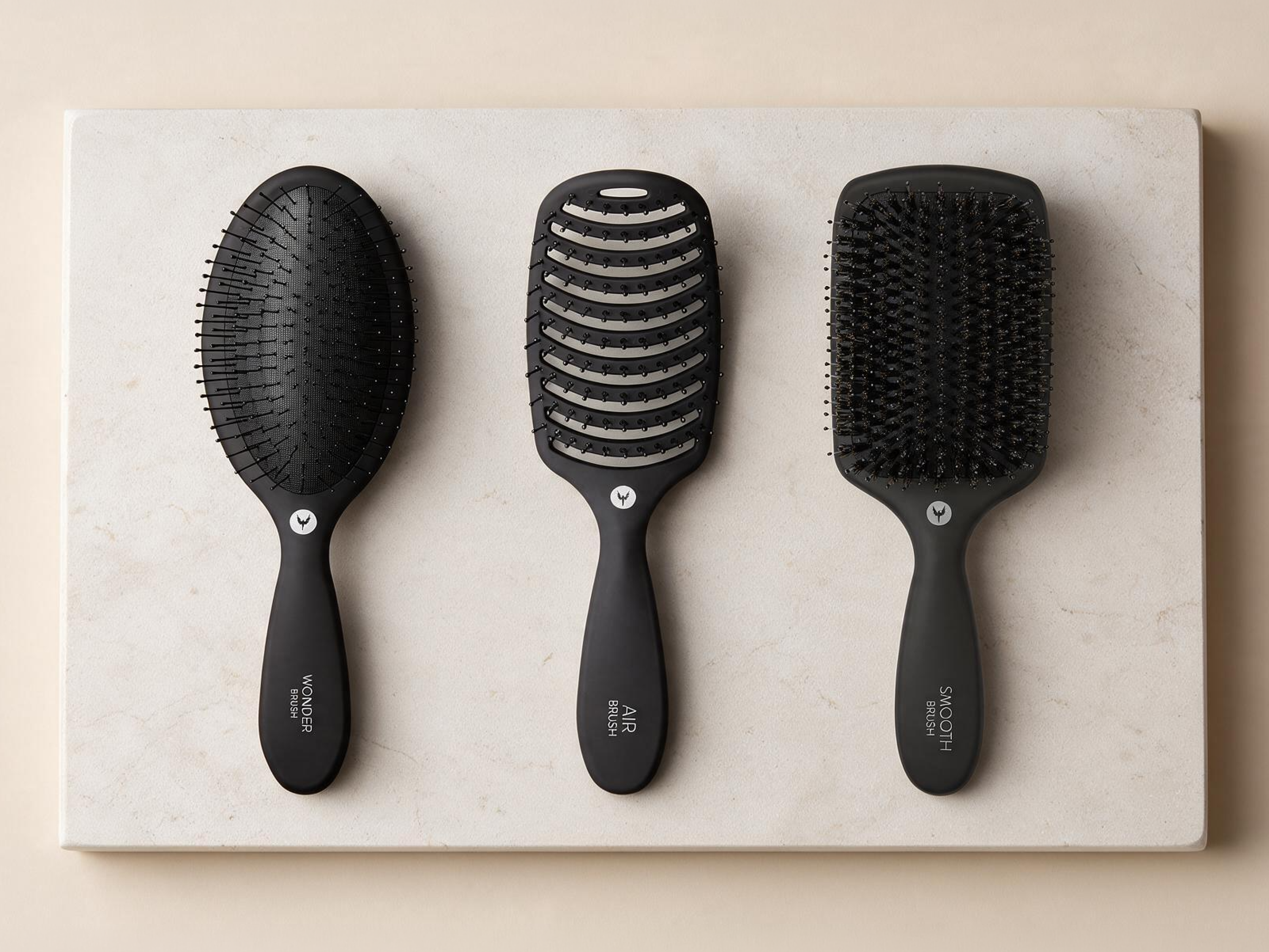 Tre sorte hårbørster: en oval Wonder Brush, en ventileret Air Brush og en rektangulær Smooth Brush.