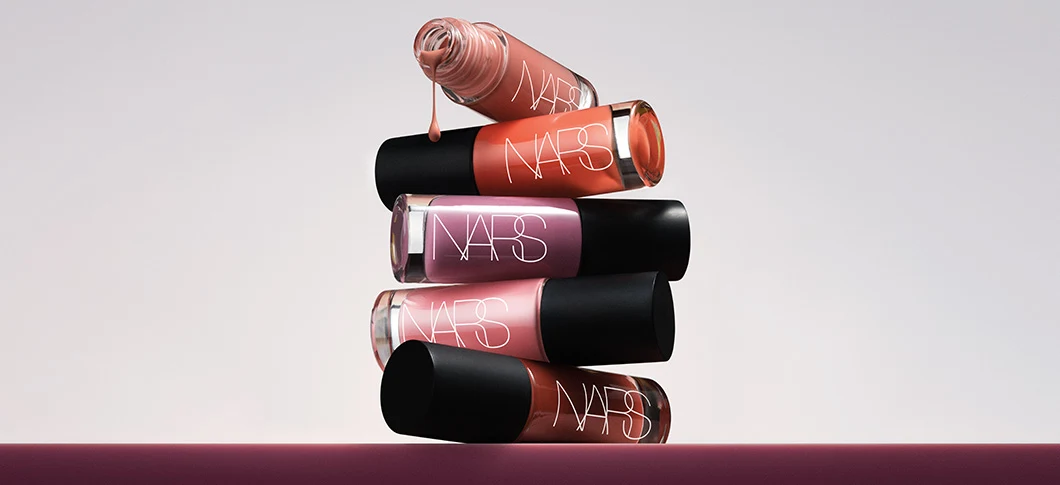 Her ses et billede med blush-produkter fra NARS placeret ovenpå hinanden mod en lys baggrund. På produkterne står teksten “NARS".