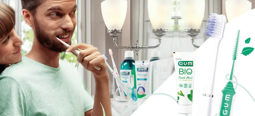 Her ses en mand, som er i færd med at børste sine tænder. Han står på et badeværelse og kigger sig selv i spejlet. Rundt omkring ses flere forskellige GUM produkter. En kvinde kigger desuden over mandens skulder.