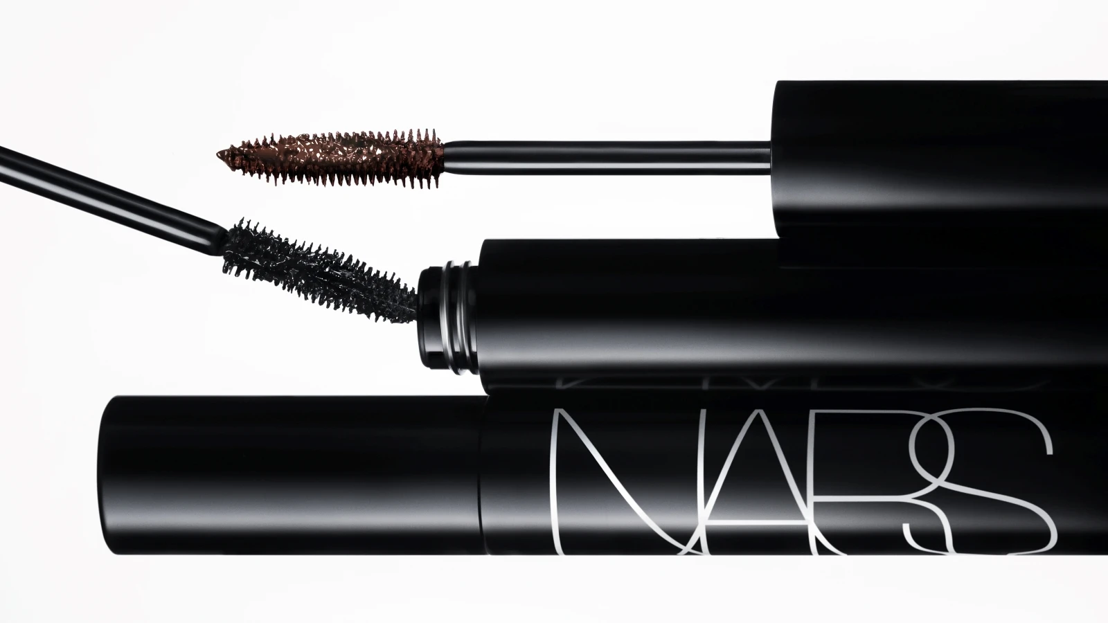 Tre NARS mascaraer. To med fremstrakte børster, der viser sort og brun mascara, og en lukket tube med NARS logoet.
