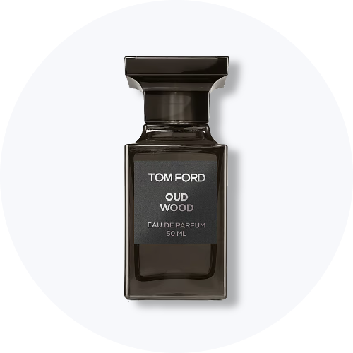 Her ses et billede af en parfumeflakon fra Tom Ford placeret centralt mod en lys, rund baggrund. På flakonen står teksten “TOM FORD OUD WOOD EAU DE PARFUM 50 ML”. Flakonen er i mørke nuancer med sort låg.