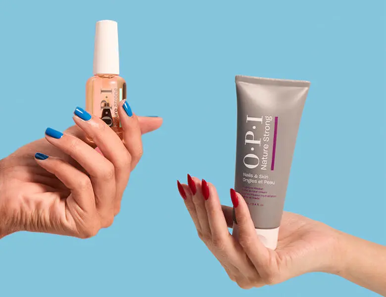 Her ses to OPI produkter i hver deres hånd holdt foran en blå baggrund.
