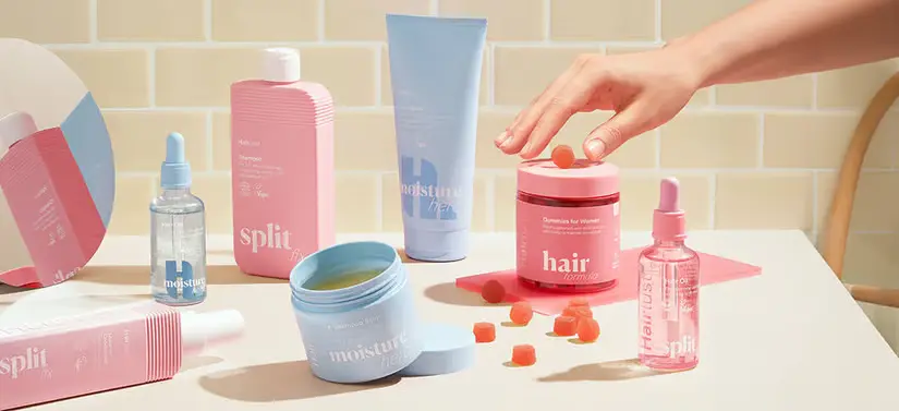 Her ses flere farverige Hairlust produkter på et badeværelse i neutrale farver.