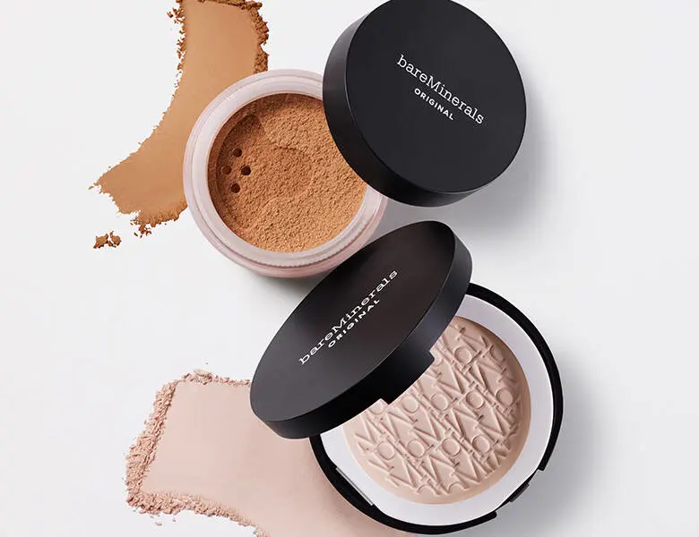 Her ses et beige bareMinerals pudder på en hvid baggrund.