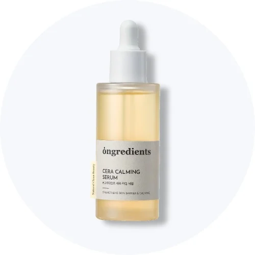 Her ses et Ongredients Cera Calming Serum i en gennemsigtig pipetteflaske på en lys baggrund.