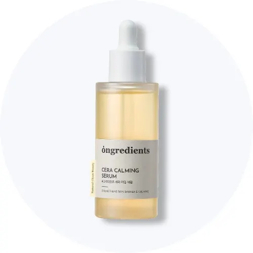 Her ses et Ongredients Cera Calming Serum i en gennemsigtig pipetteflaske på en lys baggrund.