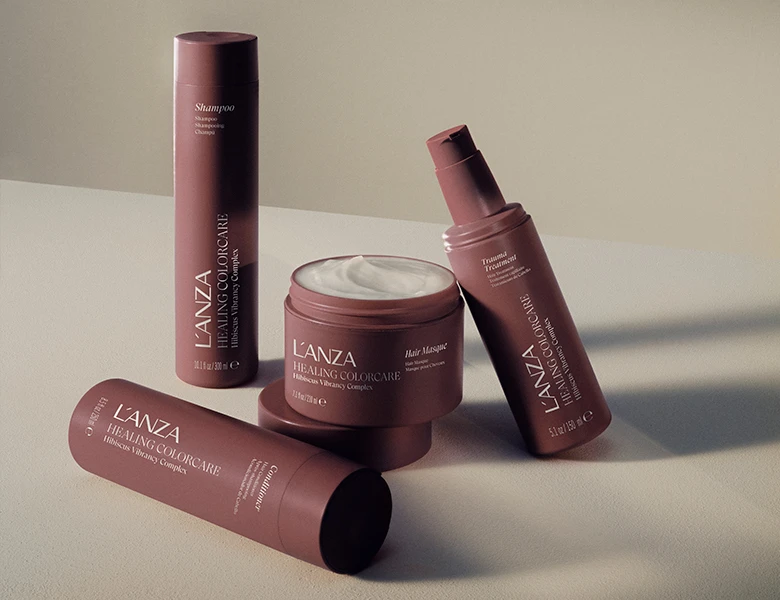 En samling L'ANZA Healing Colorcare hårprodukter, herunder shampoo, balsam, hårmaske og traumebehandling.