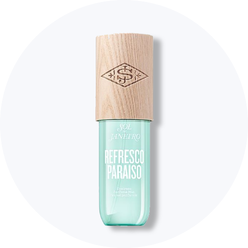 Her ses et billede af et body mist-produkt fra Sol de Janeiro placeret centralt mod en lys, rund baggrund. På produktet står teksten “SOL DE JANEIRO REFRESCO PARAISO”. Flasken er i turkis nuance med træfarvet låg.