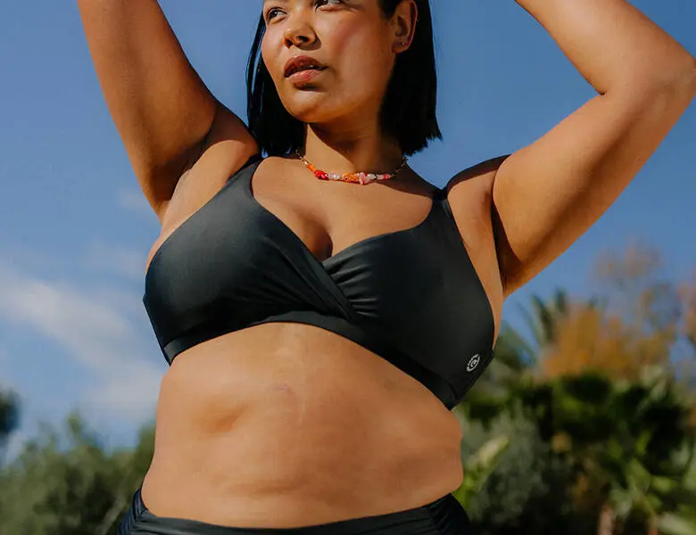 Her ses en kvinde, som er ude i det gode vejr. Hun har en sort bikini på.