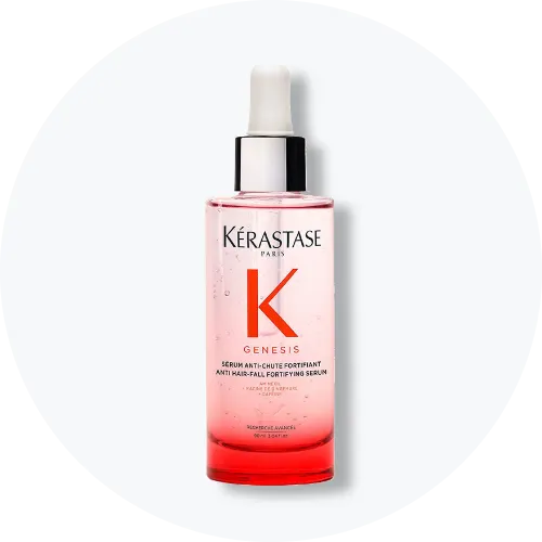 Her ses Kérastase Genesis Serum Anti-Chute Fortifiant i en transparent flaske med rosa indhold og pipette. På emballagen står blandt andet “Genesis” og “Serum Anti-Chute Fortifiant”.