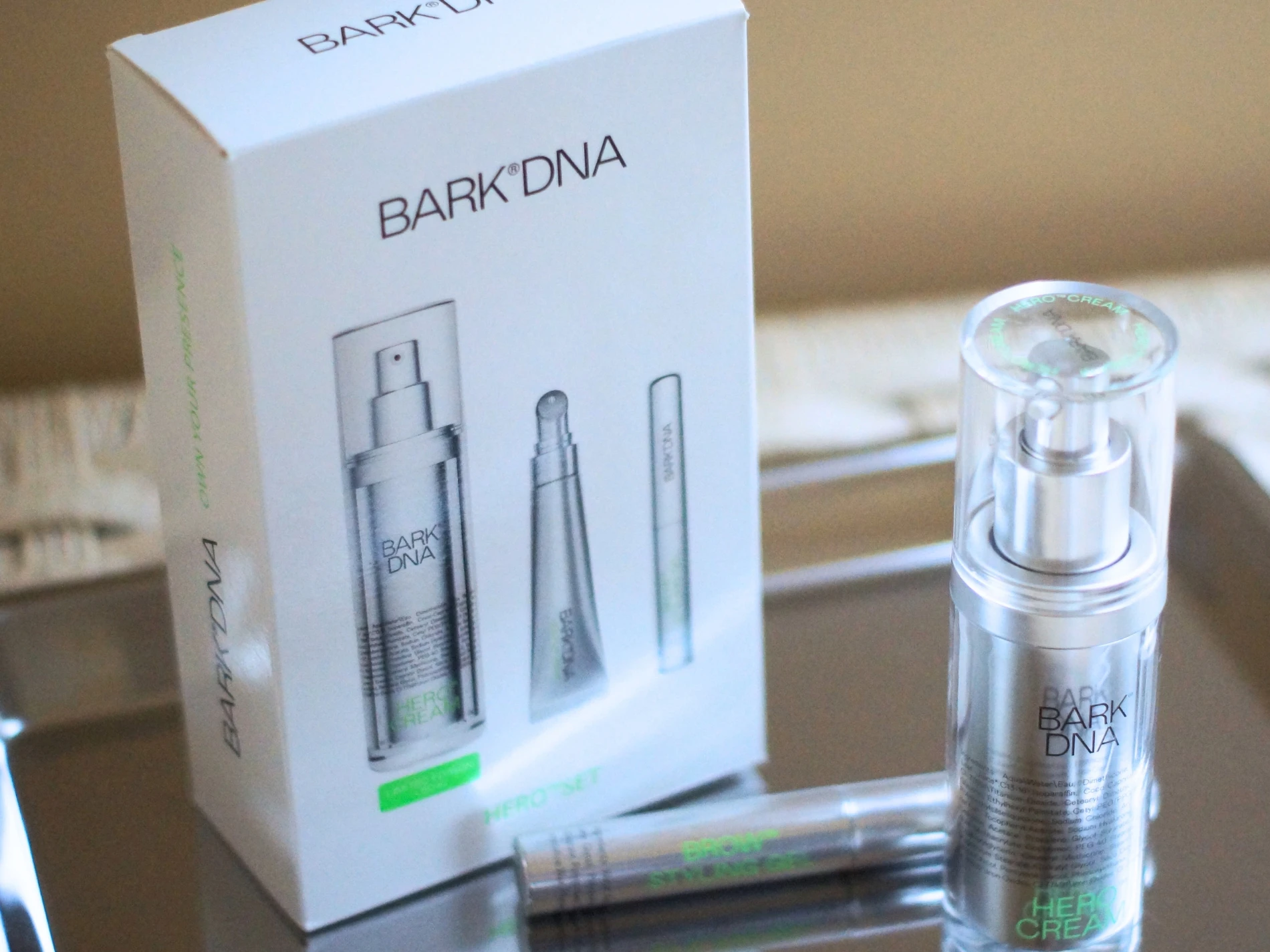 Hvid æske med BARK DNA HEROSET. Ved siden af ses en BARK DNA HERO CREAM pumpeflaske og en BROW applikator.