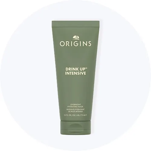 Her ses Origins Drink Up Intensive Overnight Hydrating Mask i en grøn tube på en lysegrå cirkel.