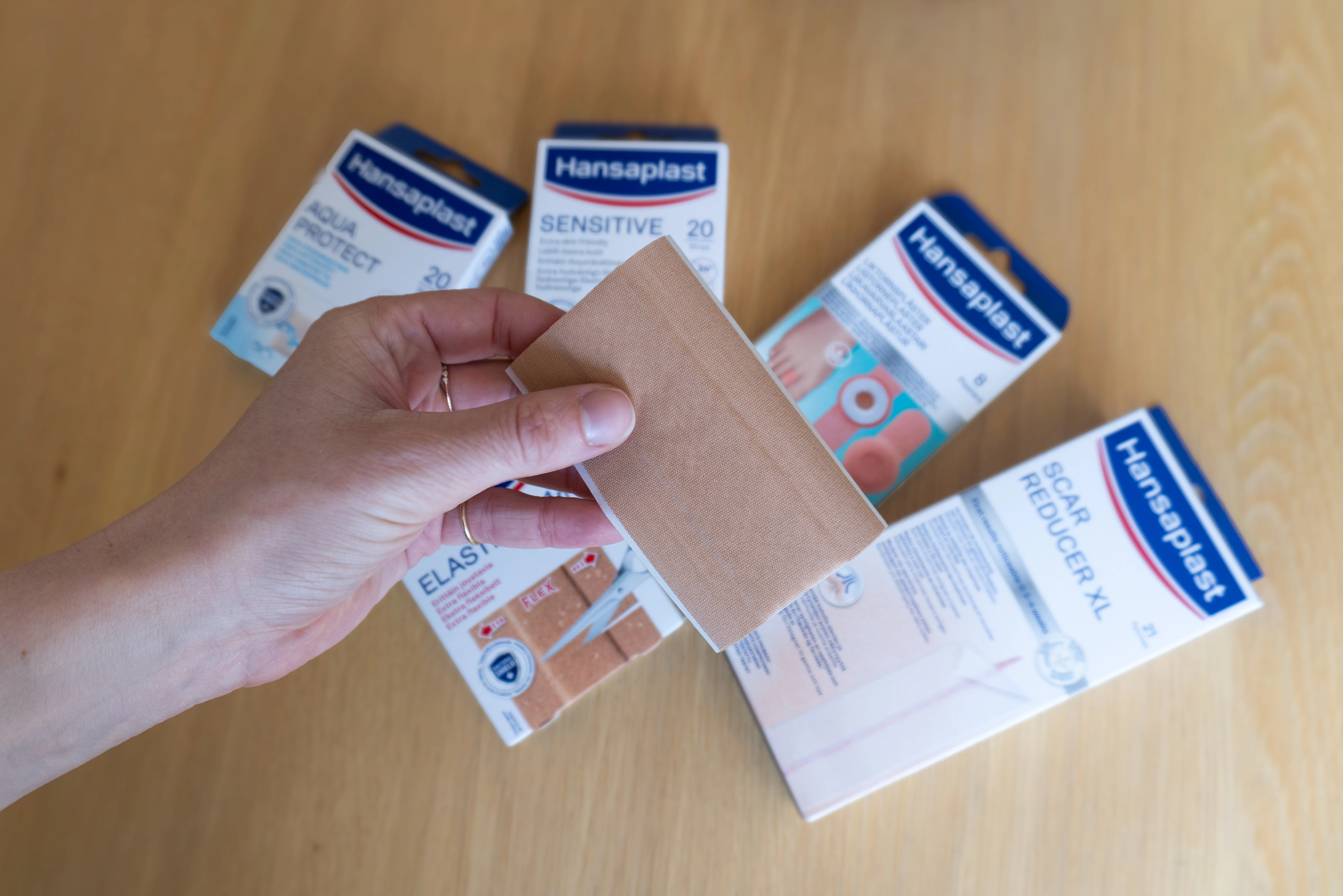 hånd der holder et plaster med pakker i baggrunden
