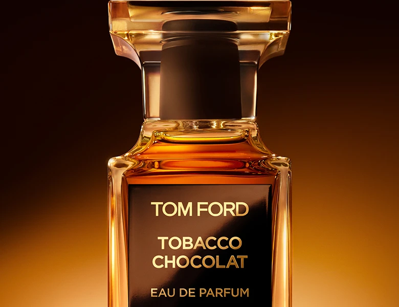 Her ses en mørkebrun baggrund med en sort Tom Ford parfume.