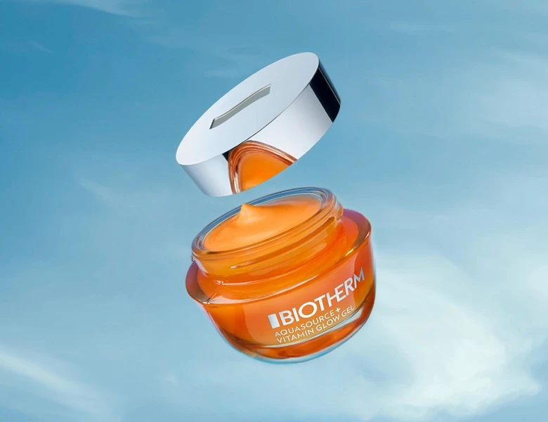Biotherm Aquasource+ Vitamin Glow Gel i en åben orange krukke med svævende sølvlåg.