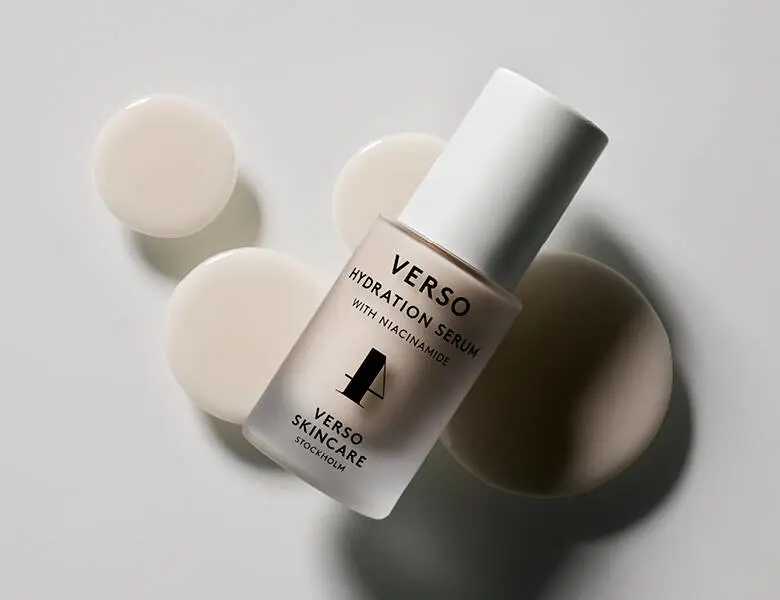 Her ses en serum fra Verso. Den ligger på nogle beige prikker og en lys baggrund.