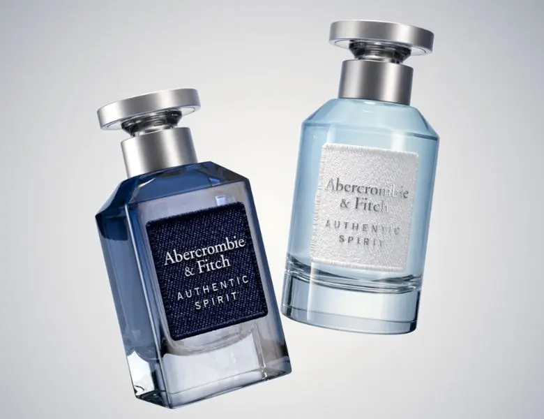 To Abercrombie & Fitch Authentic Spirit parfume. Én mørkeblå flaske med denim-etiket, én lyseblå flaske med hvid etiket.