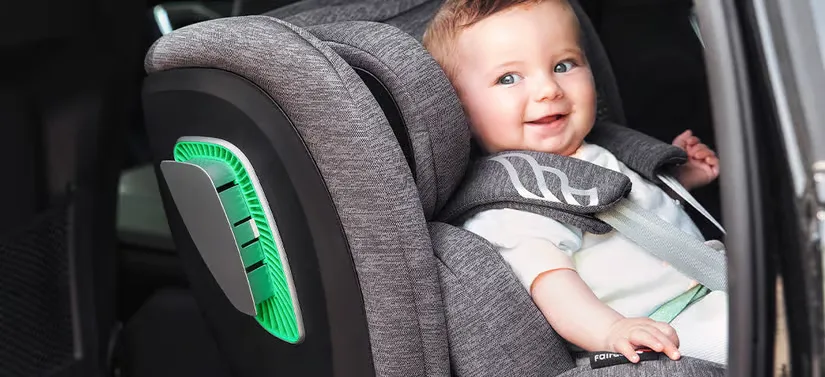 Her ses en glad lille dreng i sit babysæde. 